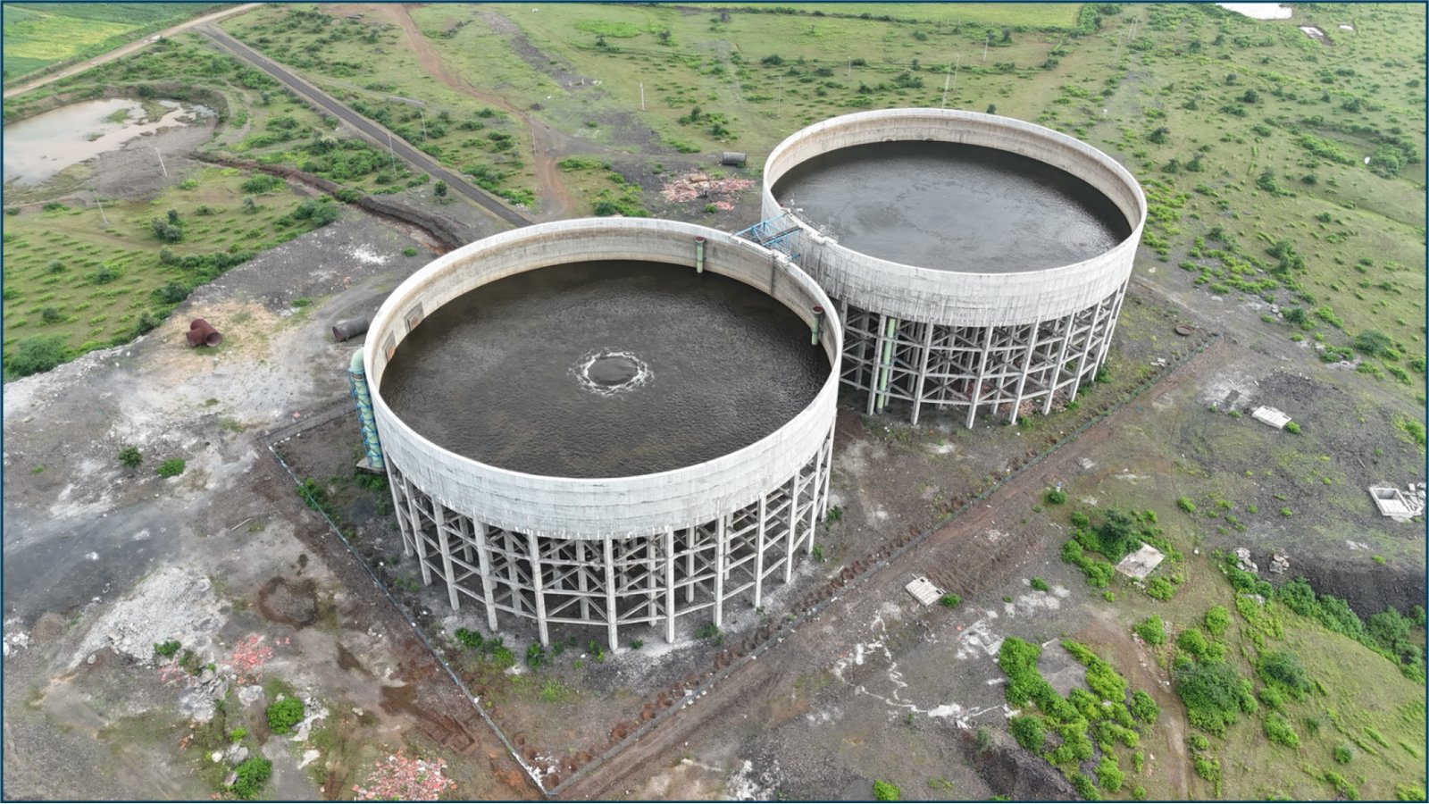 Aerial view of two large circular water storage tanks under construction
